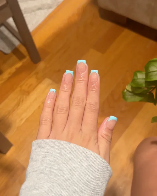Square nails with light blue French tips over a glossy natural pink base.